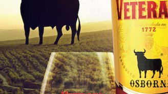 Ein Glas mit Veterano-Getränk steht vor einer weiten Landschaft, während ein schwarzer Stier im Hintergrund silhouettiert ist.