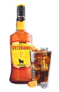 Eine Flasche Veterano mit leuchtendem Etikett steht neben einem Glas mit Eis und einer Orangenscheibe, das ein Getränk enthält.